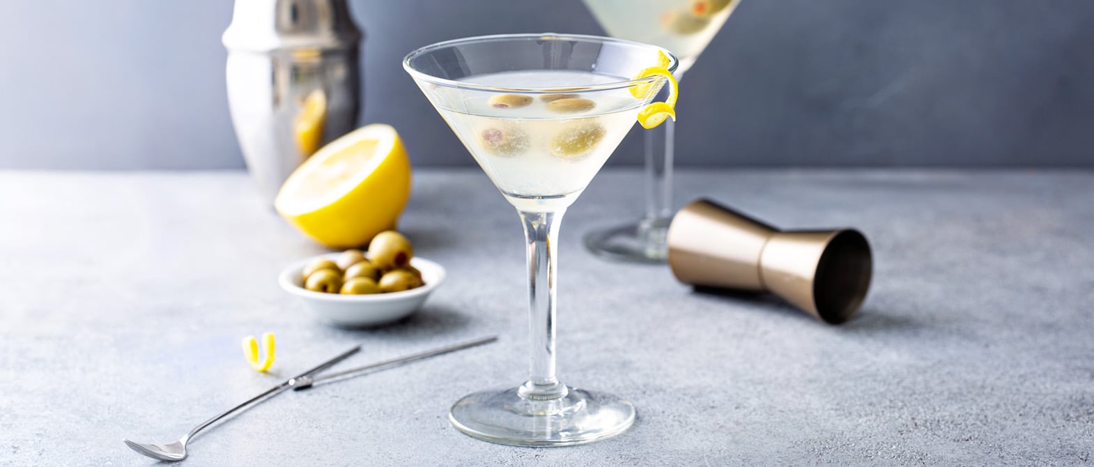 Dirty Vodka Martini cocktail with olives and a lemon twist