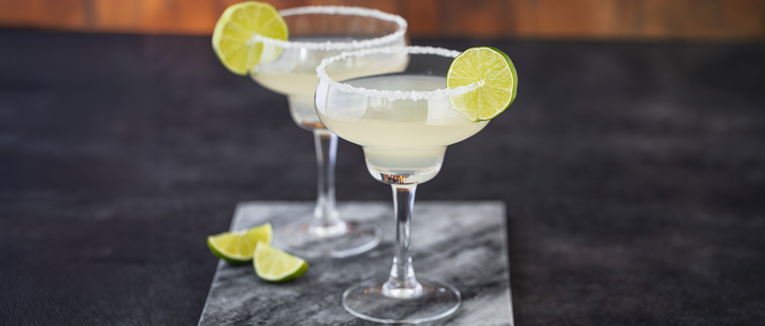 Two refreshing Margarita cocktails rimmed with salt and lime